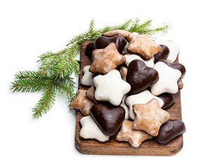 Sugar and chocolate glazed seasonal spiced cookies on wooden cutting board isolated on white
