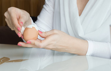 Woman hands peeling the egg 