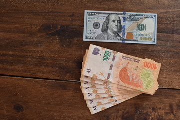 100 dollar bill with Argentine peso bills, symbolic for money exchange rate - obrazy, fototapety, plakaty