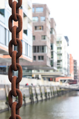 Old iron chain with street of Hamburg in background