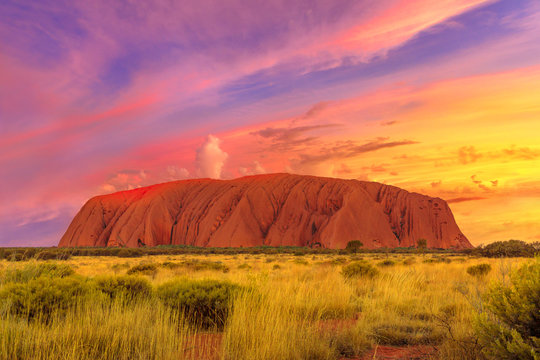 Amazing dramatic colorful sunset sky over Ayers Rock in Uluru-Kata Tjuta National Park - at Living Cultural Landscape, Australia, Northern Territory. Majestic australian outback or Red Center