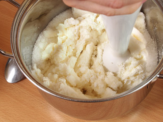 Blending curd cheese into a cream with a hand blender . Making Chocolate Layer Cake with Cream...