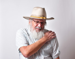 Old Caucasian man with a long white beard showing extreme physical pain. Concept of medical problems old people suffer from, including extreme pain.
