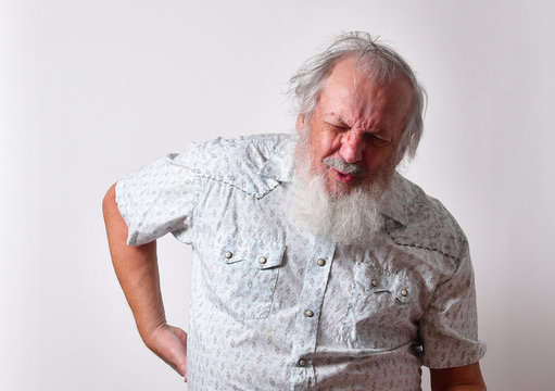 Old Caucasian man with a long white beard showing extreme physical pain. Concept of medical problems old people suffer from, including extreme pain. Back pain seems to be the most common type of pain.