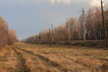 autumn rural road along the railway. the road on which rarely goes transport.