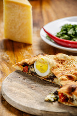 Italian vegetable pie with an egg, cheese and a spicy pepper