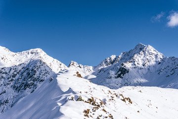 The snowy mountains, the nature and the landscape of the Valtellina after the first snowfall of the season in the Alps, near the town of Tartano, Italy - November 2019.