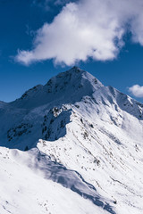 The snowy mountains, the nature and the landscape of the Valtellina after the first snowfall of the season in the Alps, near the town of Tartano, Italy - November 2019.
