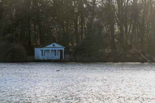 The sun illuminates the trees and glitters on the lake at Gut Panker near Kiel, Germany