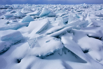 Fototapeta na wymiar Landscape of blue ice shards and snow covered shoreline of Lake Michigan, Empire Beach, Sleeping Bear Dunes, Michigan, USA