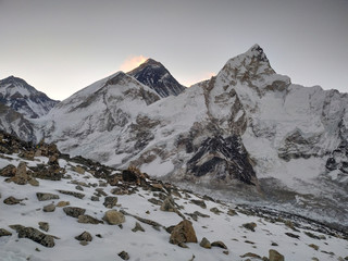 Everest mountain in Himalayas just before sunrise. Colorful snow is blown away from the top. View...