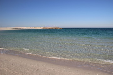 Empty calm sea bay with sand beach in sunny day