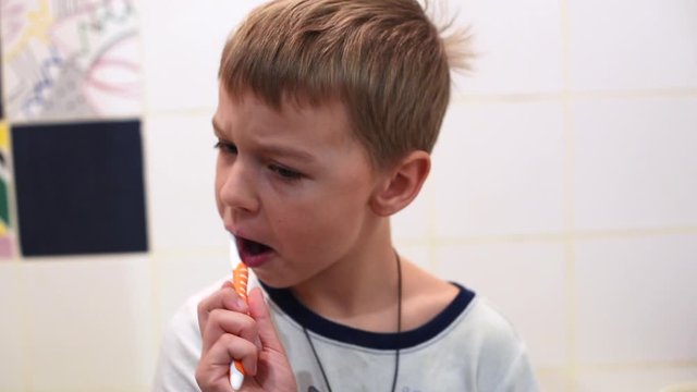 little boy brushing his teeth in the bathroom