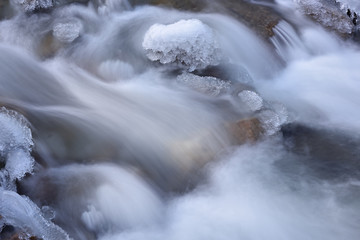 Winter landscape of Boulder Creek captured with motion blur and framed by ice, Rocky Mountains, Colorado, USA