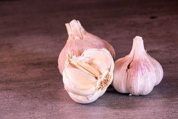 three large heads of pink garlic on a kitchen worktop