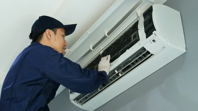 Technician service placing back clean filter into air conditioner