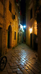 Fototapeta premium Medieval vintage narrow street with ancient stone pavers in old european city Kotor in Montenegro at night
