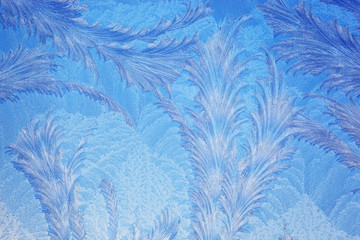 Frost forms in patterns on window glass on a cold winter morning