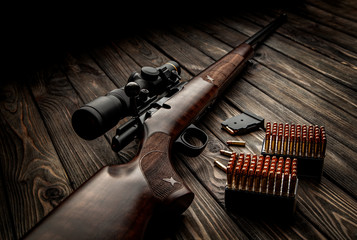 Classic bolt carbine .22lr with a wooden butt with a telescopic sight on a dark wooden background....