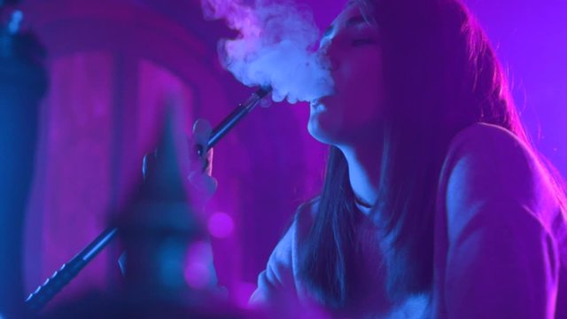 Slow motion young woman enjoying hookah at the bar feel happy young friendship communicate emotion shisha smoker male lounge handsome female vape beautiful attractive company relax