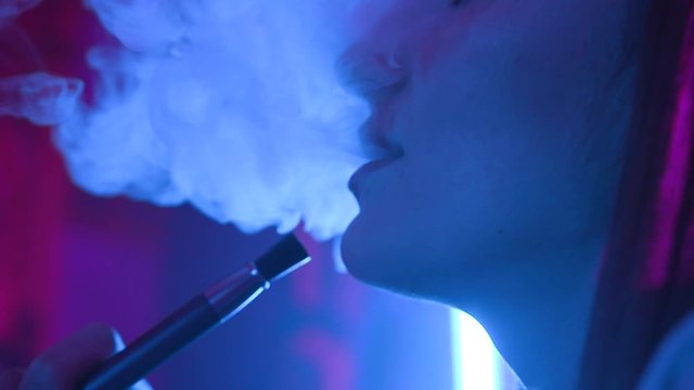 Close up face young woman enjoying hookah at the bar feel happy young friendship communicate dark shisha smoker lounge female vape beautiful attractive company relax slow motion