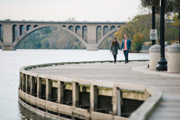 Couple holding hands and walking along the boardwalk in Georgetown, Washington DC