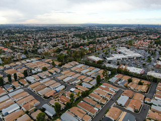 Aerial view of urban sprawl. Suburban packed homes neighborhood with road.during clouded day. Vast subdivision in Irvine, California, USA