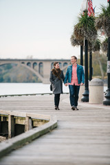 Couple holding hands and walking along the boardwalk in Georgetown, Washington DC - 312688835