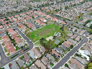 Aerial view of urban sprawl. Suburban packed homes neighborhood with road. Vast subdivision in Irvine, California, USA