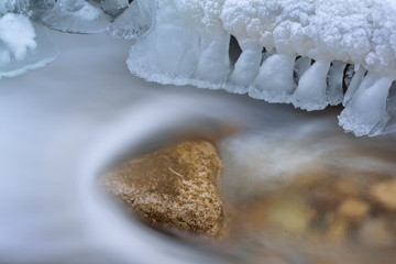 Winter Orangeville Creek cascade framed with icicles and captured with motion blur, Michigan, USA