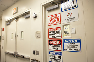 Warning signs on door at chemical plant