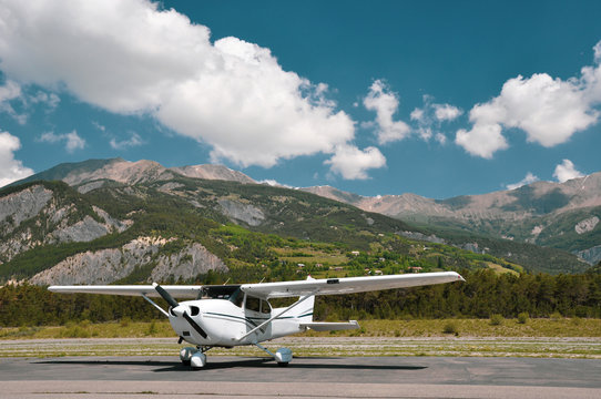 Single engine piston Cessna 172 parked at an airfield in the mountains