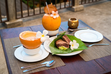 Delicious asian food served on the terrace with coconuts