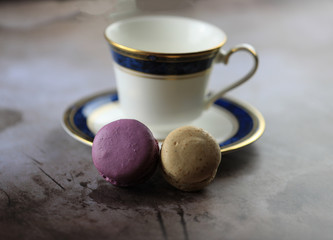 Two vegan gluten free macarons lean against a saucer