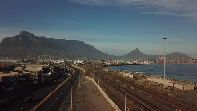 4K high quality aerial sunny morning footage of industrial Transnet harbour, Table Mountain, busy highways, city center, Atlantic Ocean Table Bay panorama, Western Cape, Cape Town, South Africa