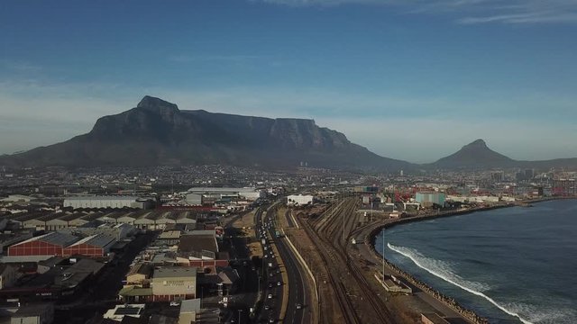 4K high quality aerial sunny morning footage of industrial Transnet harbour, Table Mountain, busy highways, city center, Atlantic Ocean Table Bay panorama, Western Cape, Cape Town, South Africa