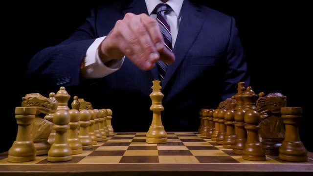 Confident Business Leader Places King on Chess Game Board