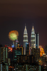 Fototapeta na wymiar KUALA LUMPUR, MALAYSIA - 1ST JANUARY 2020; Fireworks explode near Malaysia's landmark Petronas Twin Towers during New Year celebrations in Kuala Lumpur.