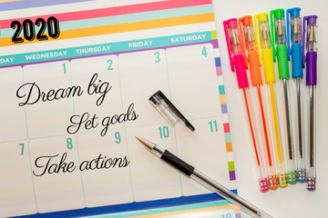 2020 Calendar for planning and ideas writing with rainbow pens on the side. Dream big. Set goals. Take actions