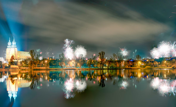 New Year fireworks over Gniezno, Poland; night view to the gothic cathedral upon the lake. Winter 2020