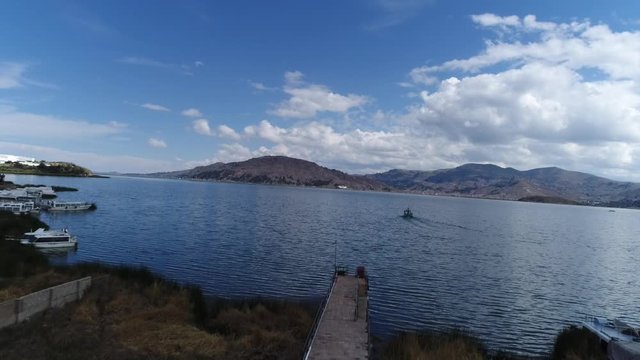 drone movement in the city of Puno on a beautiful sunny day over Titicaca lake, Peru