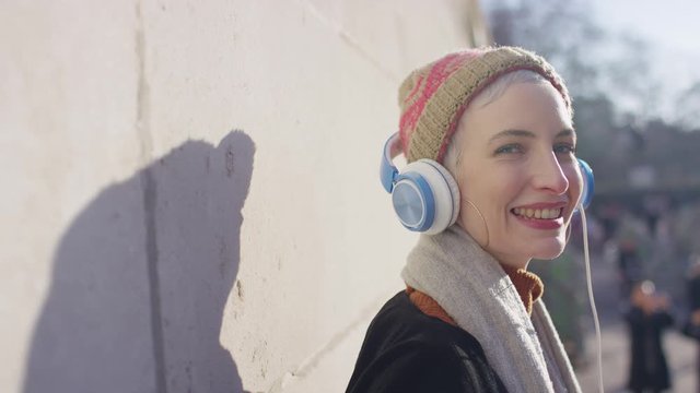 Portrait of happy smiling female wearing headphones looking to camera 