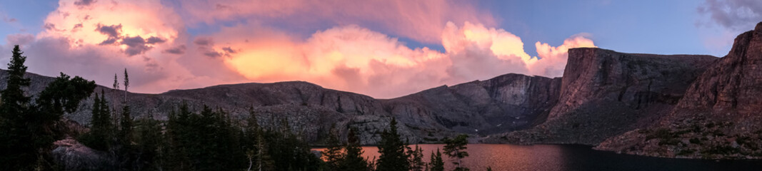 Panorama of pink sunset on mountain lake