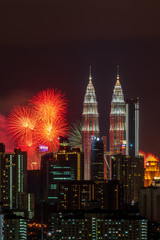 Fototapeta premium KUALA LUMPUR, MALAYSIA - 1ST JANUARY 2020; Fireworks explode near Malaysia's landmark Petronas Twin Towers during New Year celebrations in Kuala Lumpur.