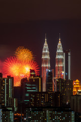 Fototapeta na wymiar KUALA LUMPUR, MALAYSIA - 1ST JANUARY 2020; Fireworks explode near Malaysia's landmark Petronas Twin Towers during New Year celebrations in Kuala Lumpur.
