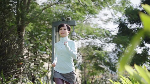 Asian beauty jogging outdoor in city park slow motion