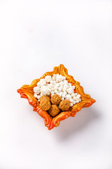 sesame seed ball or til ke laddo and tilgul in bowl on white background , sweet dish for indian festival makar sankrat 