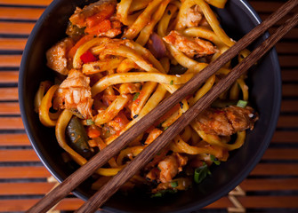 Udon noodles with chicken meat in bowl. Top view. Close up