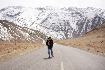 Travelers thai woman travel visit and posing for take photo with landscape high range mountain on Srinagar Leh Ladakh highway at Leh Ladakh village in Jammu and Kashmir, India at winter season