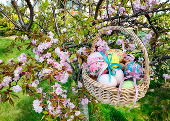 Wicker basket with Easter eggs in the garden.